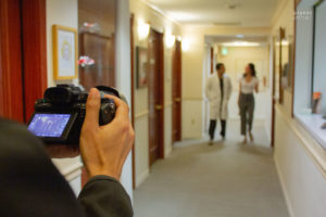 filming a medical professional walking down the hall with assistant